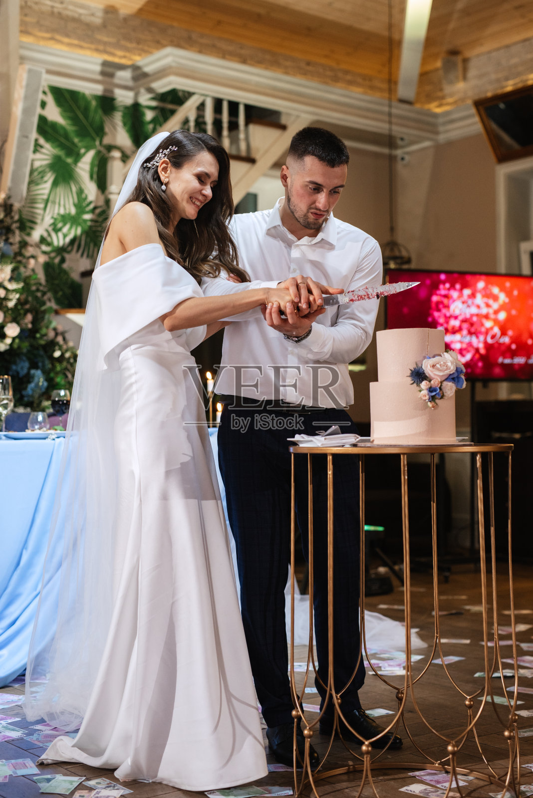 新婚夫妇愉快地切蛋糕，品尝婚礼蛋糕照片摄影图片