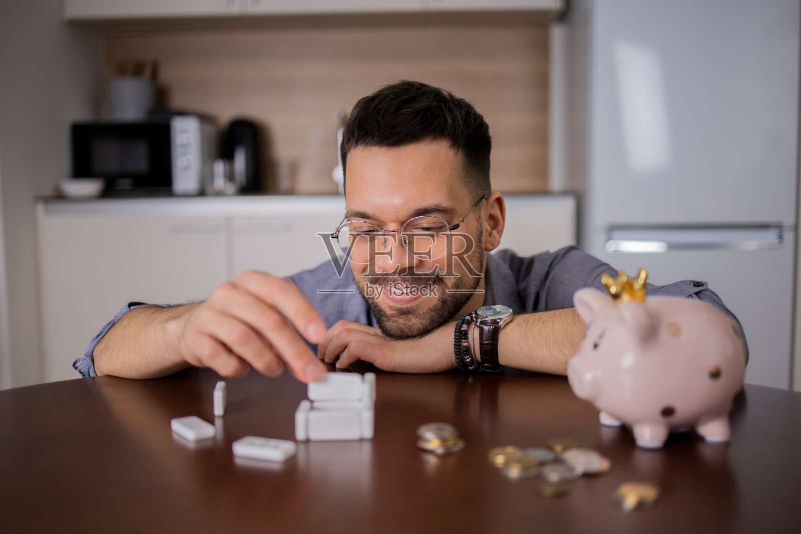 男人在存钱罐里存钱照片摄影图片