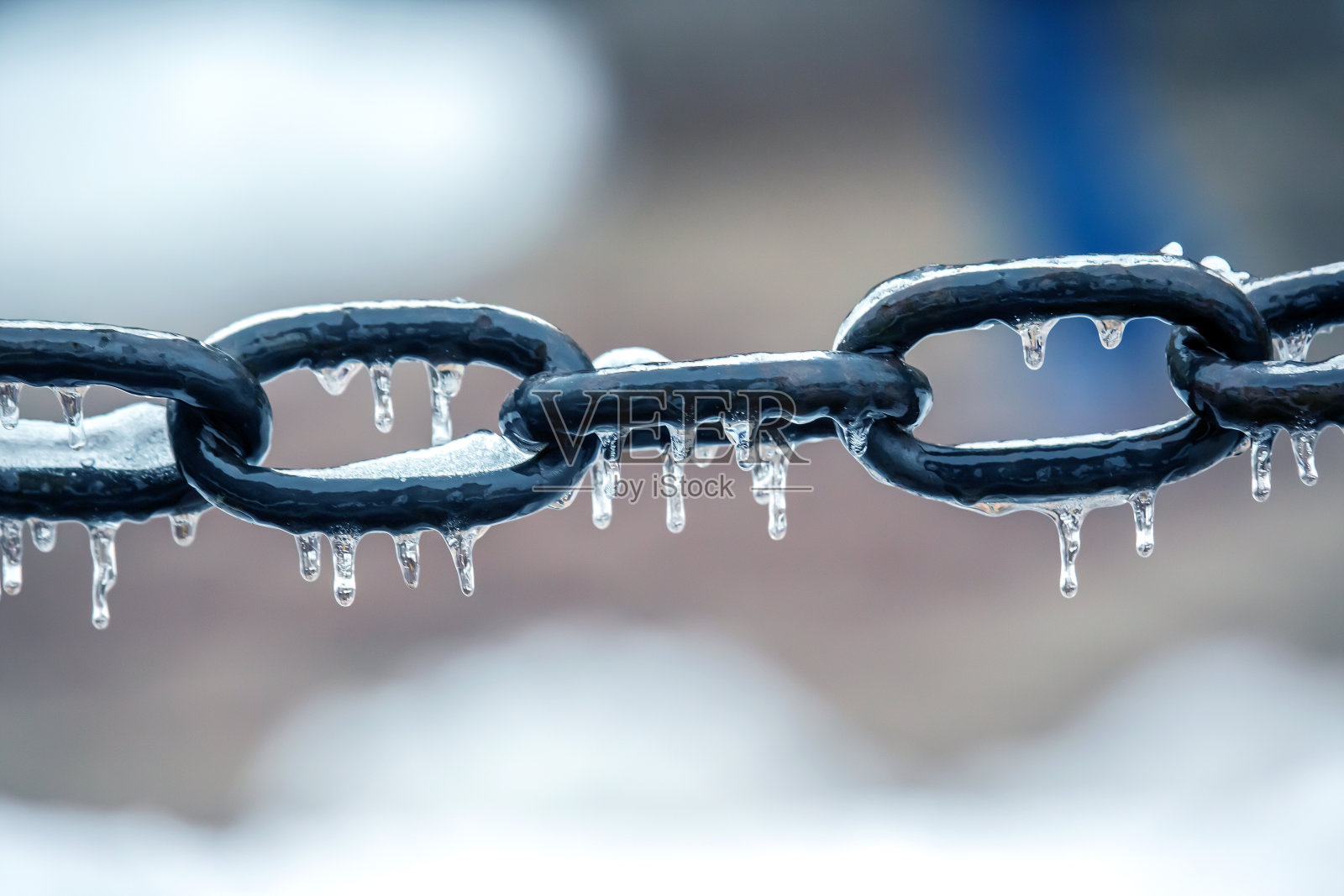 冰冻金属链上的冰柱。冬季天气季节。街道内部细节照片摄影图片