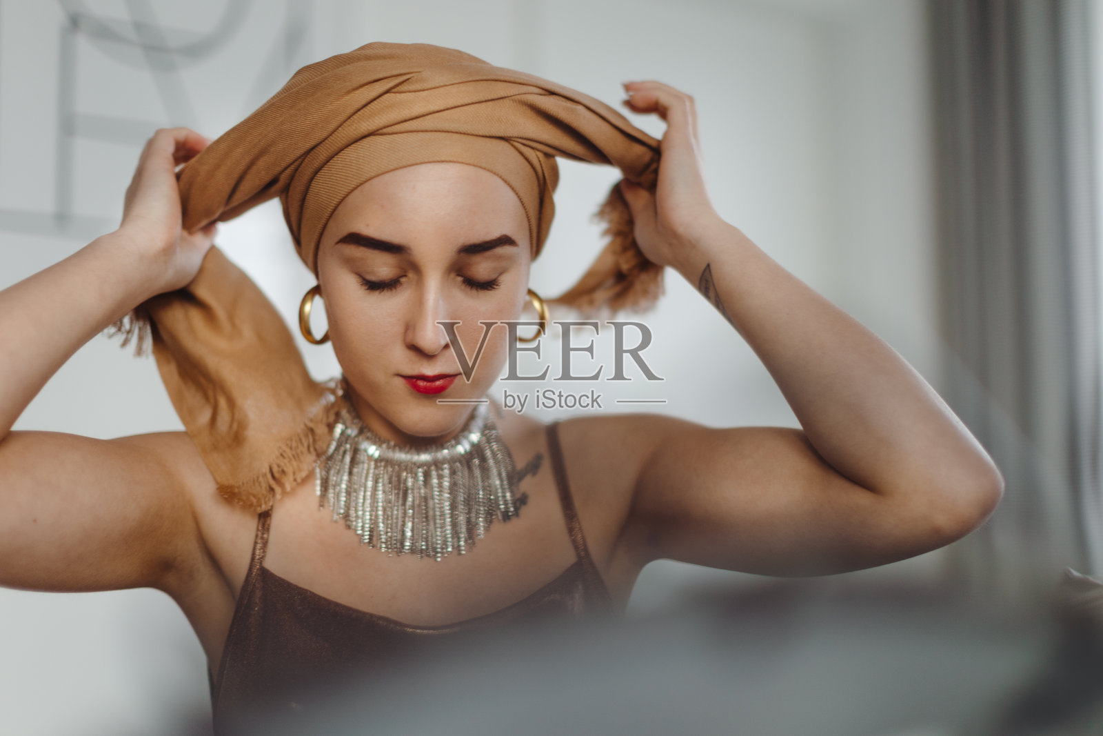 患有癌症的年轻女性的美容例行公事，头上戴着围巾。照片摄影图片