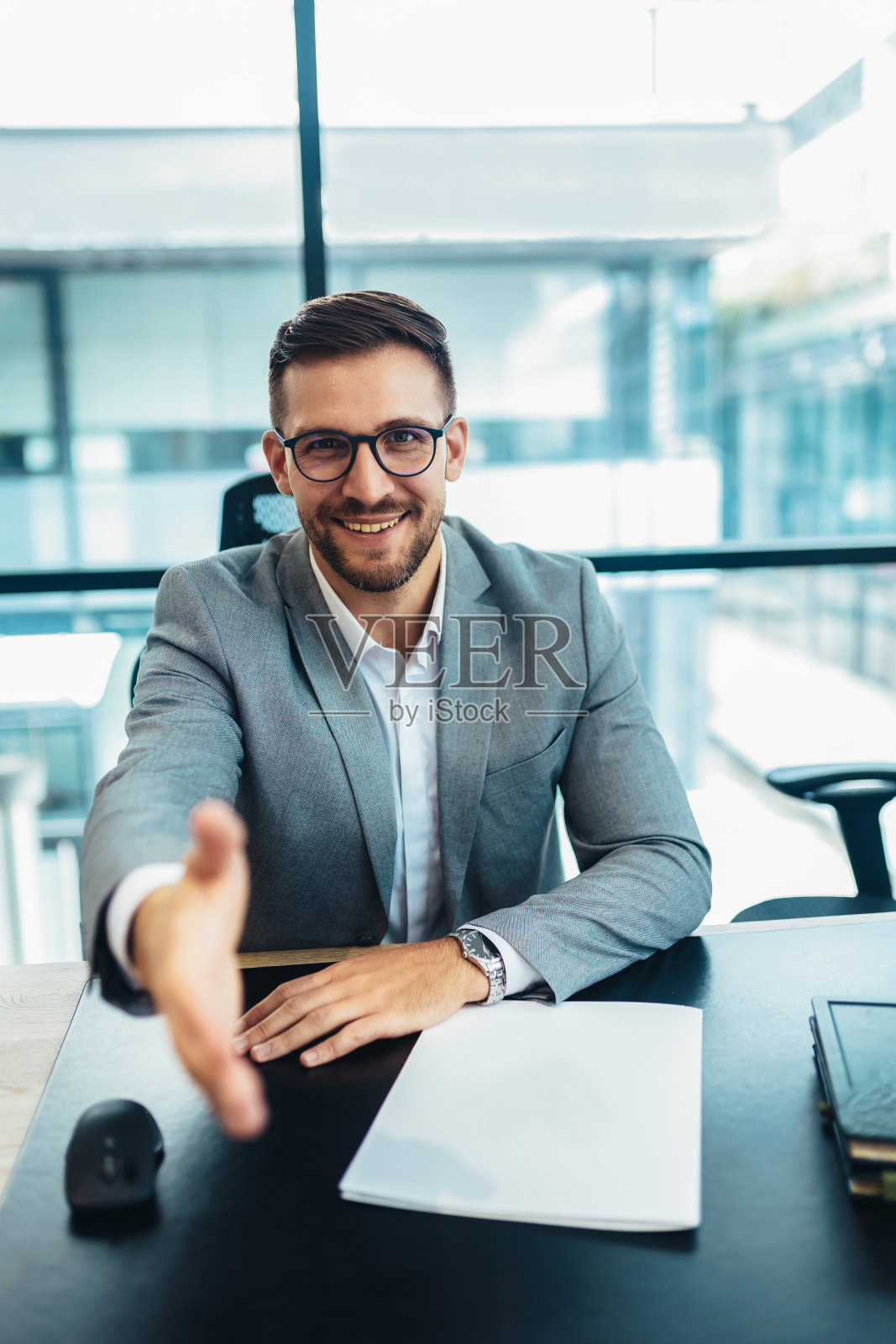 积极的商人伸出他的手，在办公室。照片摄影图片
