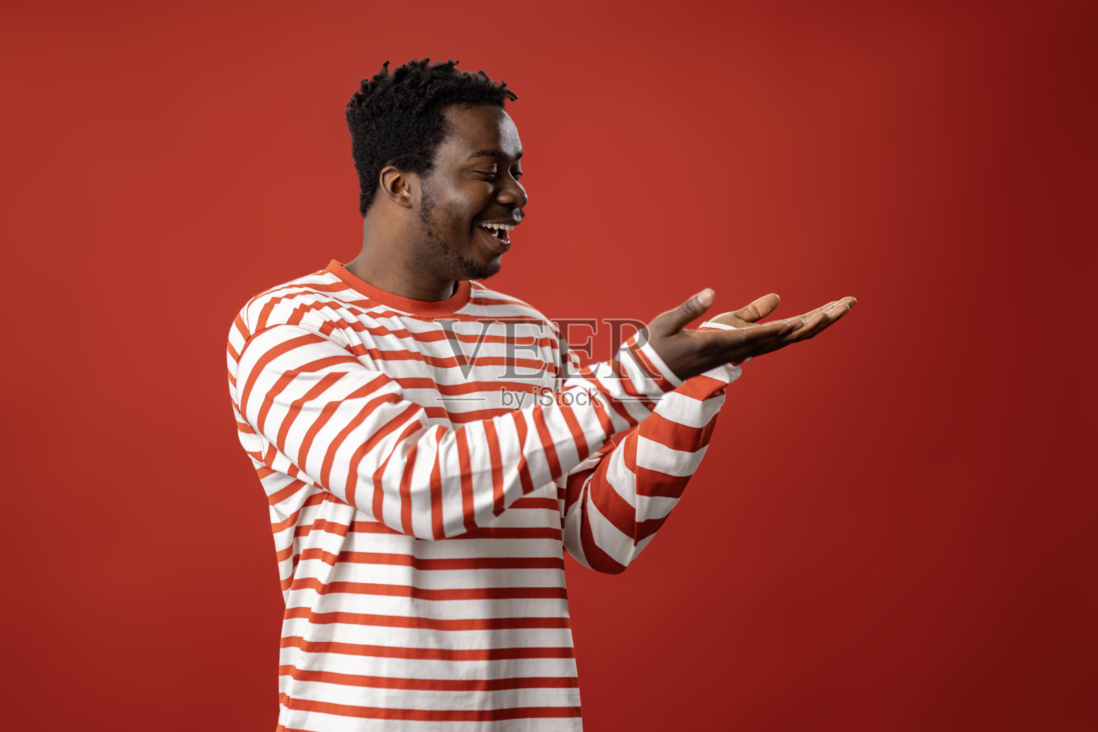 快乐的黑人，红色背景下的广告空白。照片摄影图片