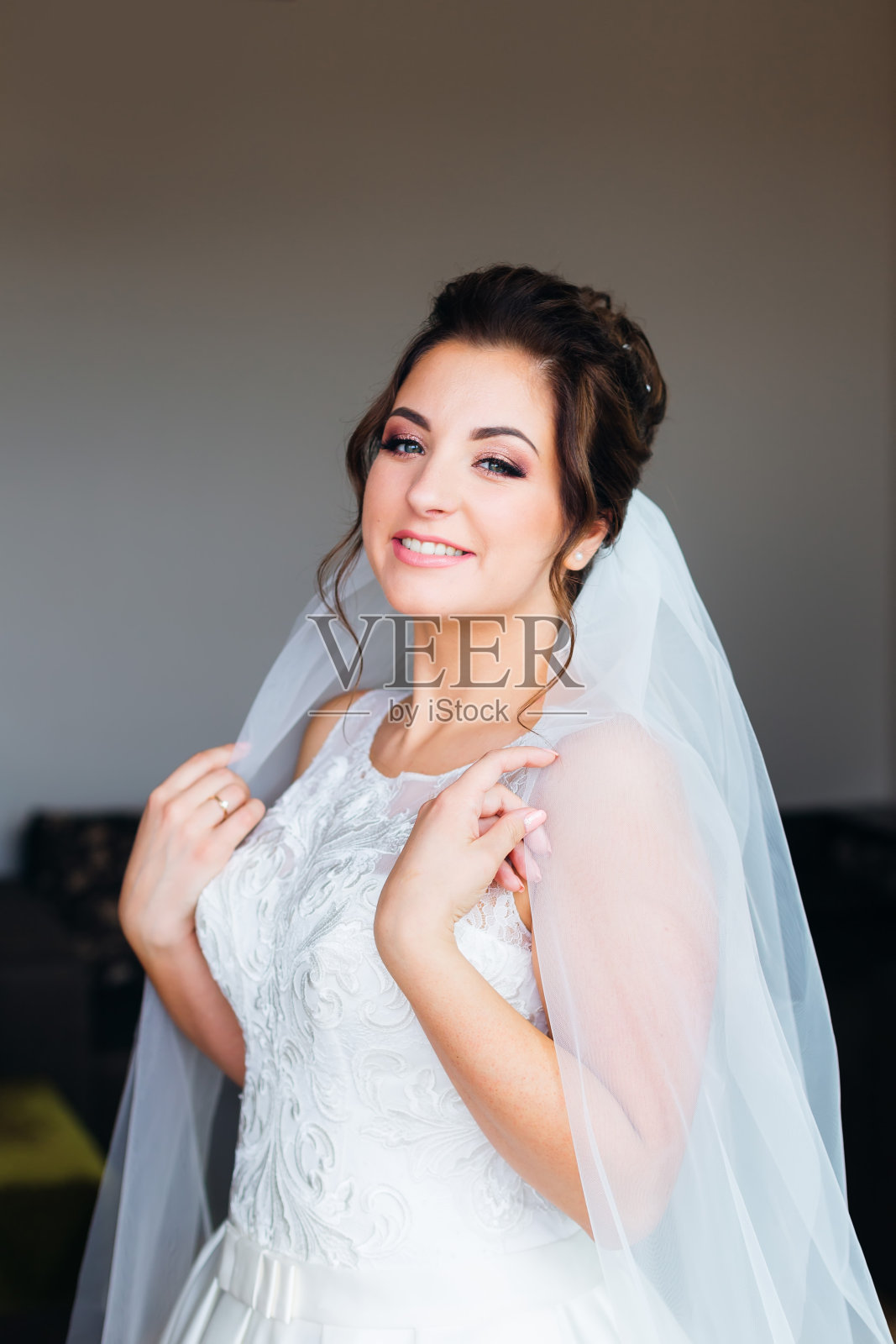 美丽的新娘看着镜头微笑。蕾丝连衣裙照片摄影图片