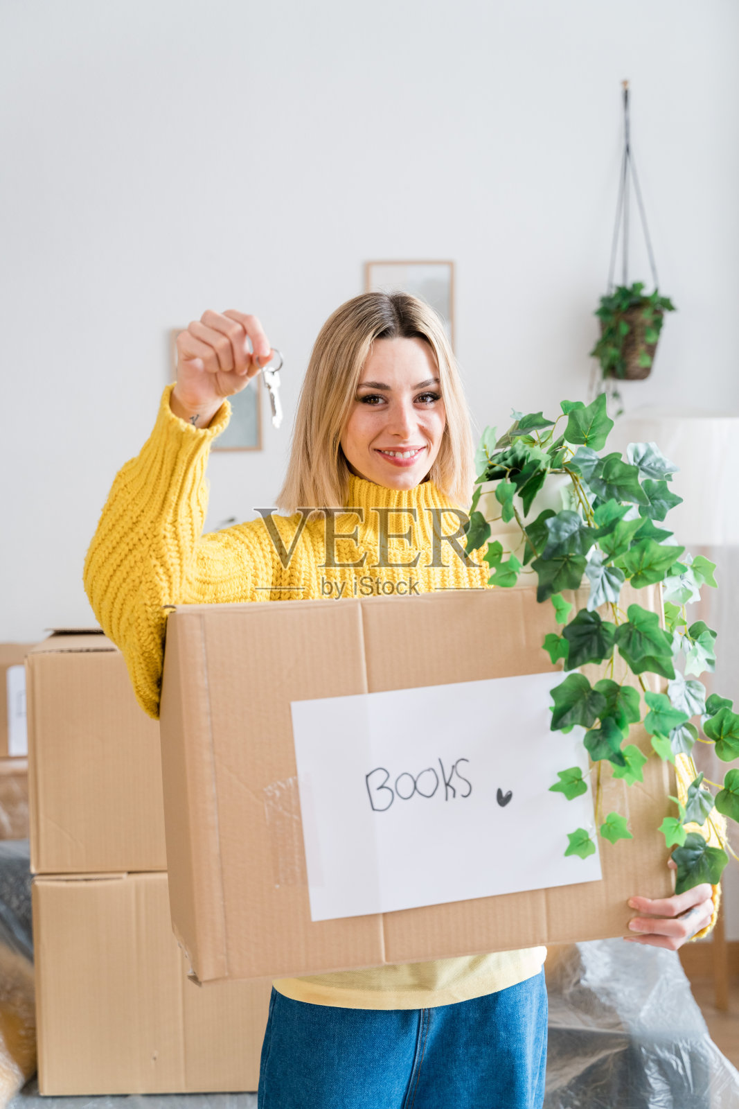 带着新房子钥匙的纸箱的快乐女人照片摄影图片