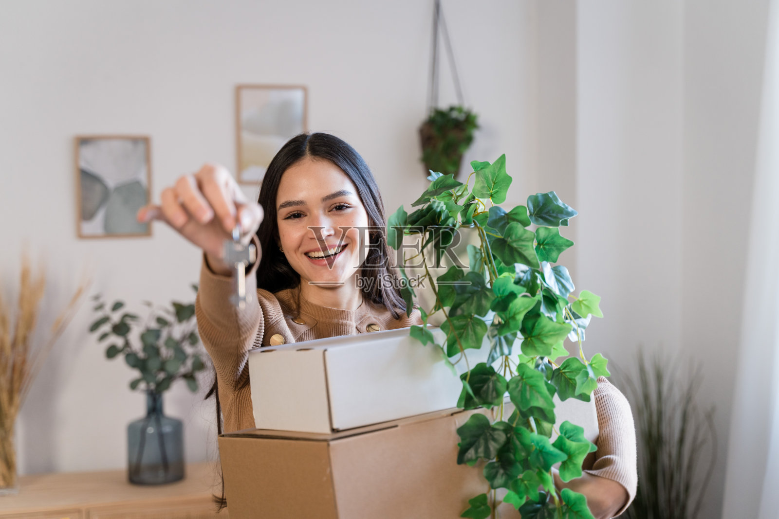 客厅里拿着卡通盒子的快乐女人正准备搬家照片摄影图片