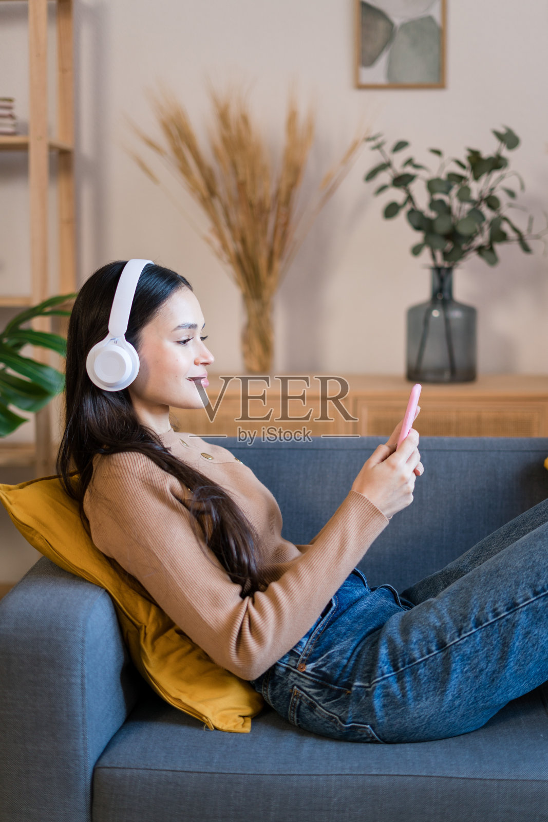 年轻女子戴着耳机使用智能手机照片摄影图片