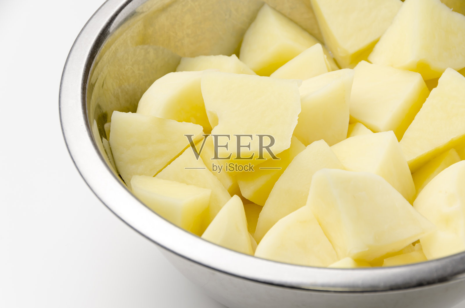 切好的生土豆放入不锈钢碗中照片摄影图片
