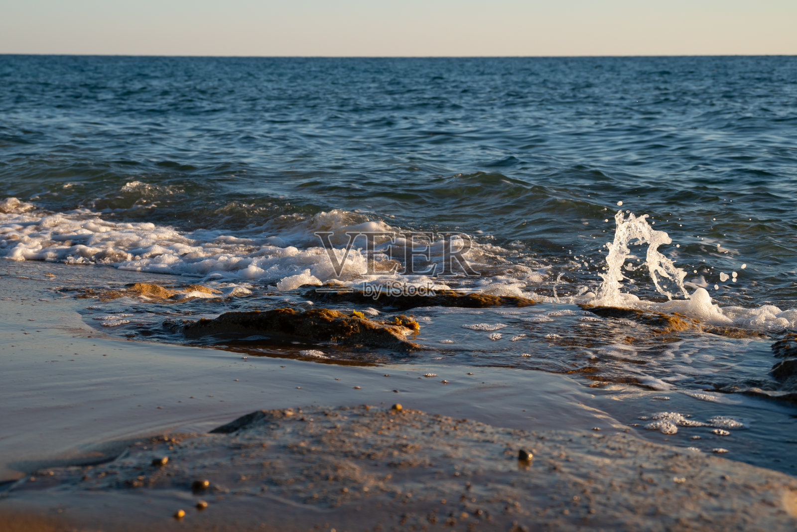 近距离的沙滩和爱奥尼亚海的海浪日落，科孚岛，希腊库努拉海滩。高质量照片照片摄影图片