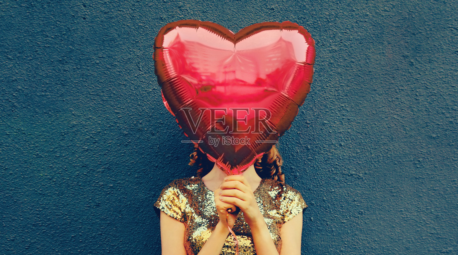 近距离女子覆盖她的头与大红色心形气球在黑暗的背景照片摄影图片