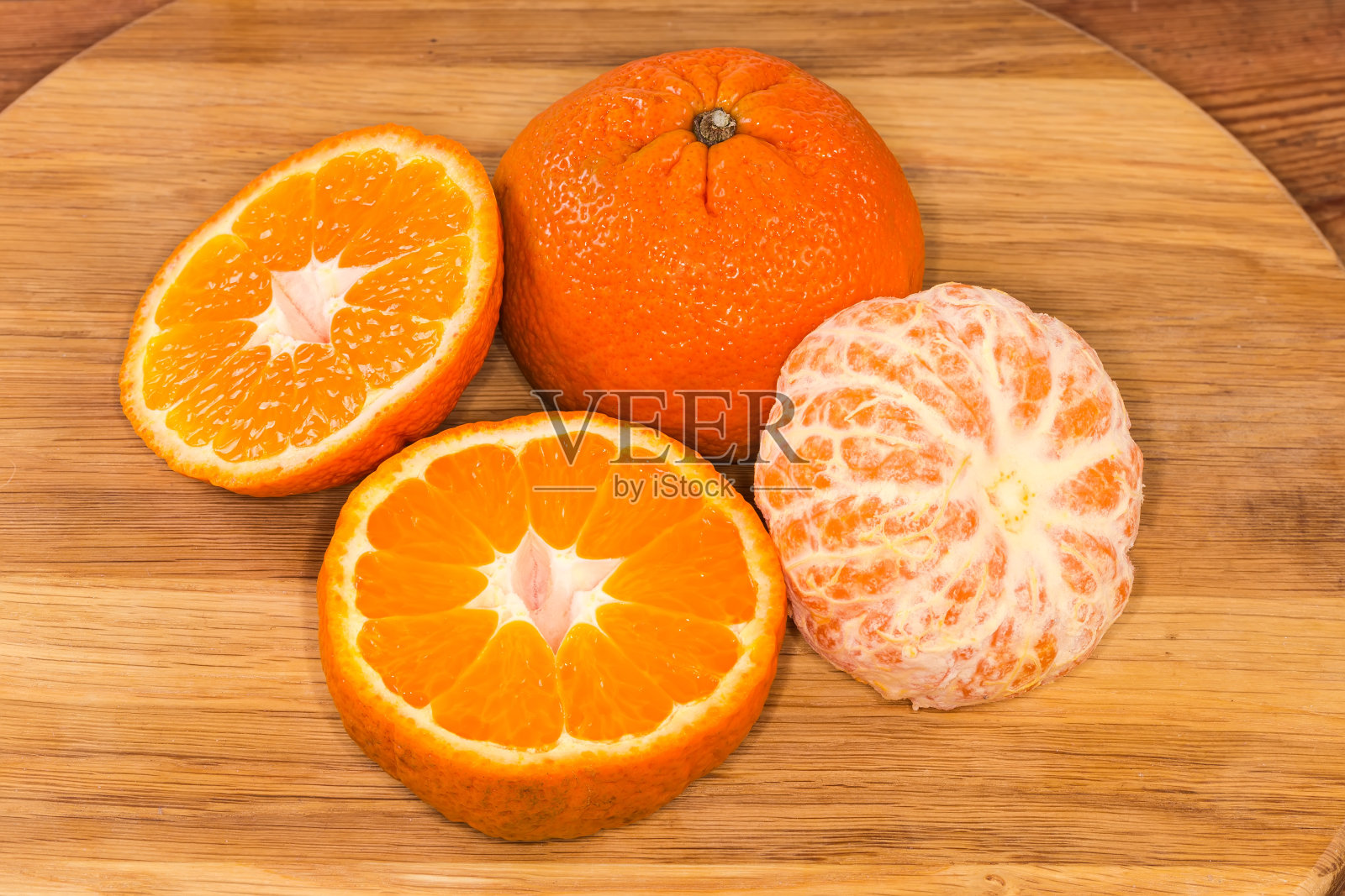 将整个、对半切开、去皮的橘子放在木面上照片摄影图片