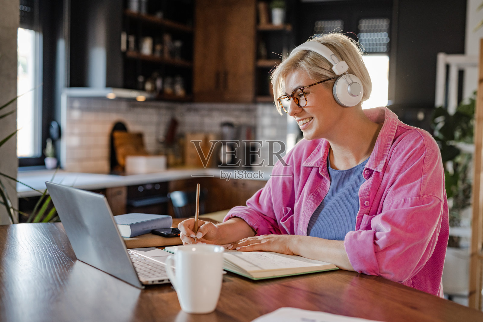 年轻女子在视频通话中写笔记照片摄影图片