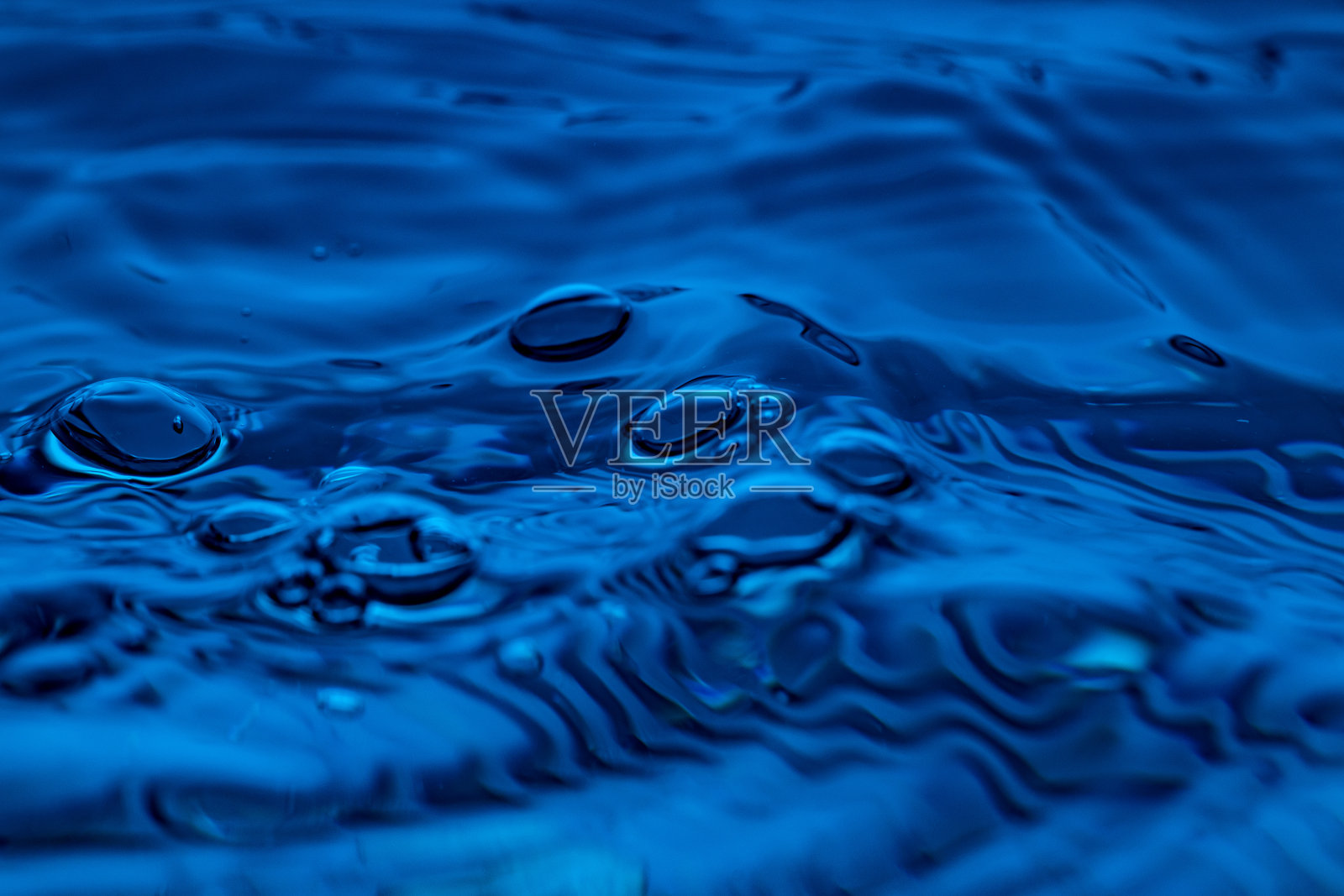 水滴溅在蓝色玻璃上照片摄影图片