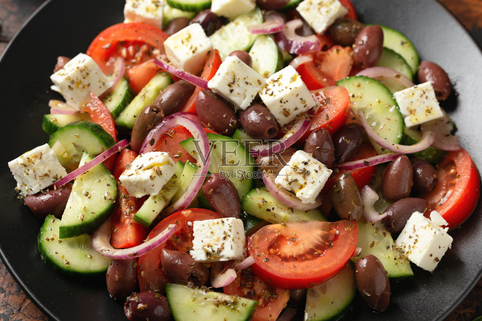希腊沙拉配新鲜蔬菜，羊乳酪，卡拉玛塔橄榄，干牛至，红酒醋和橄榄油。健康食品。照片摄影图片