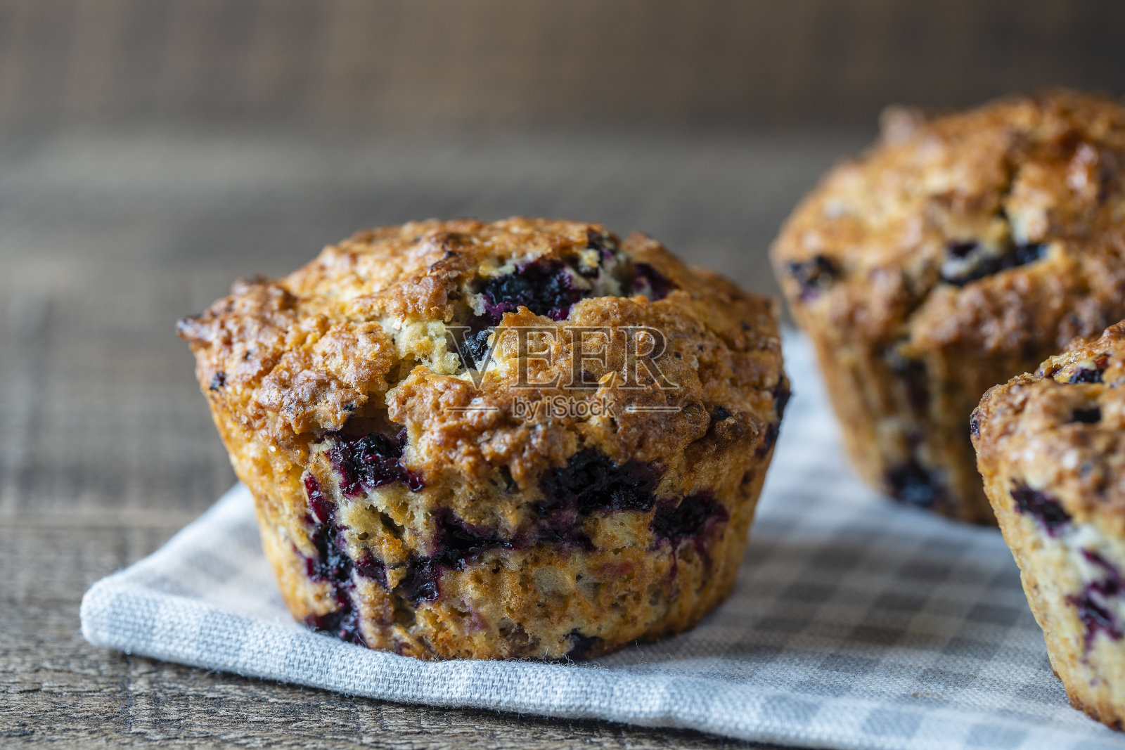 美味的松饼和蓝莓放在木桌上，特写。甜点在板子上。早餐新鲜纸杯蛋糕照片摄影图片