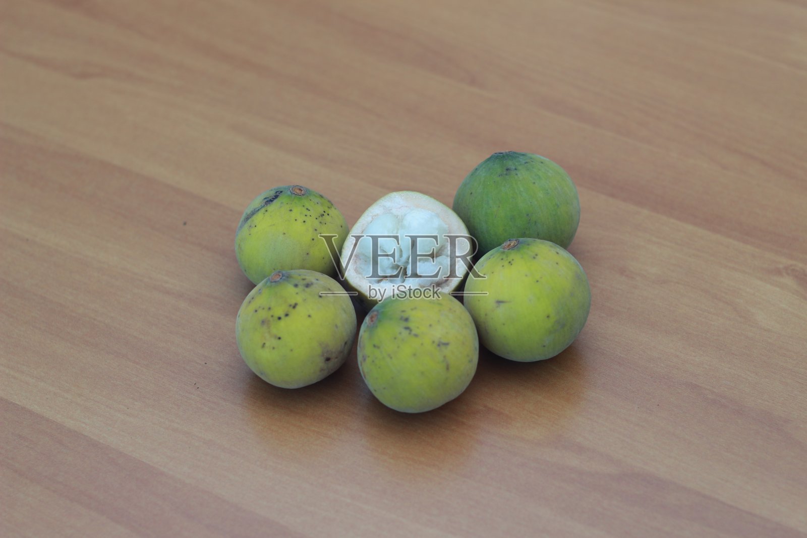 钱桌上分离的黄绿色竖琴果，酸甜可口。食物概念图。照片摄影图片