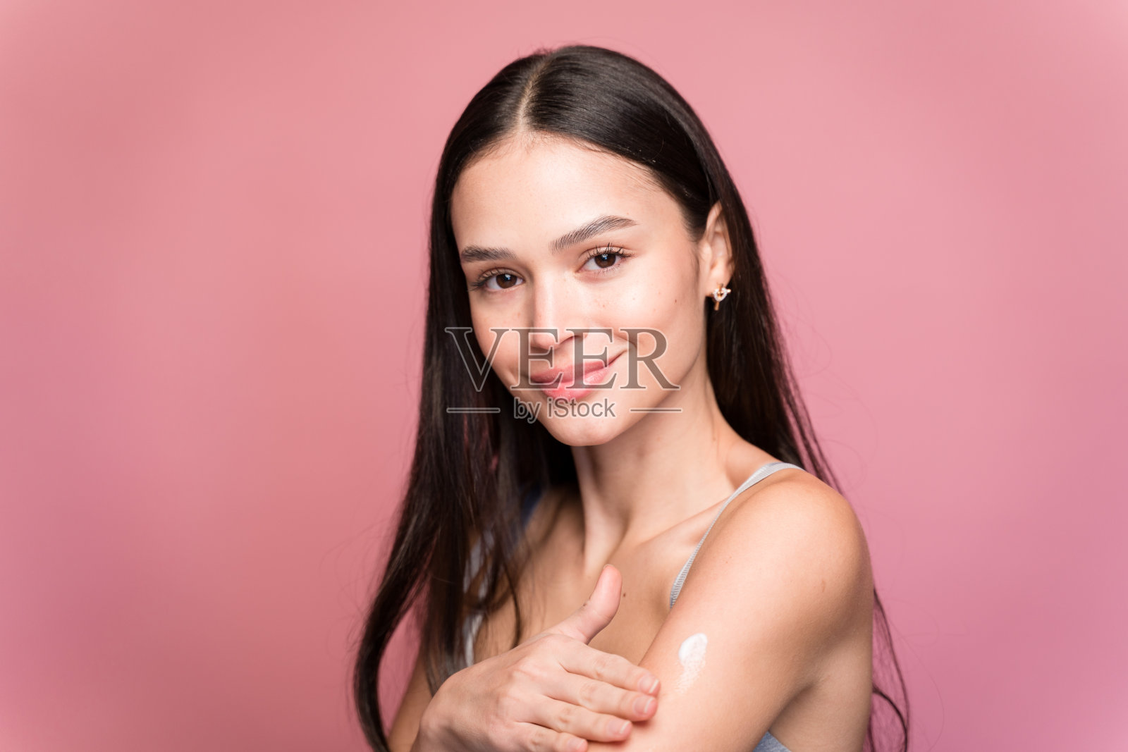 年轻女子闭着眼睛涂保湿霜照片摄影图片