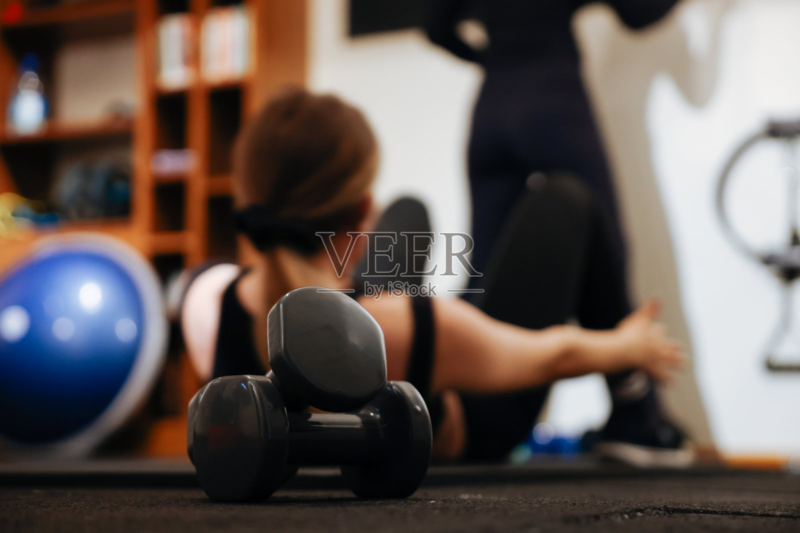 年轻的健身女子在家里做运动工作室照片摄影图片