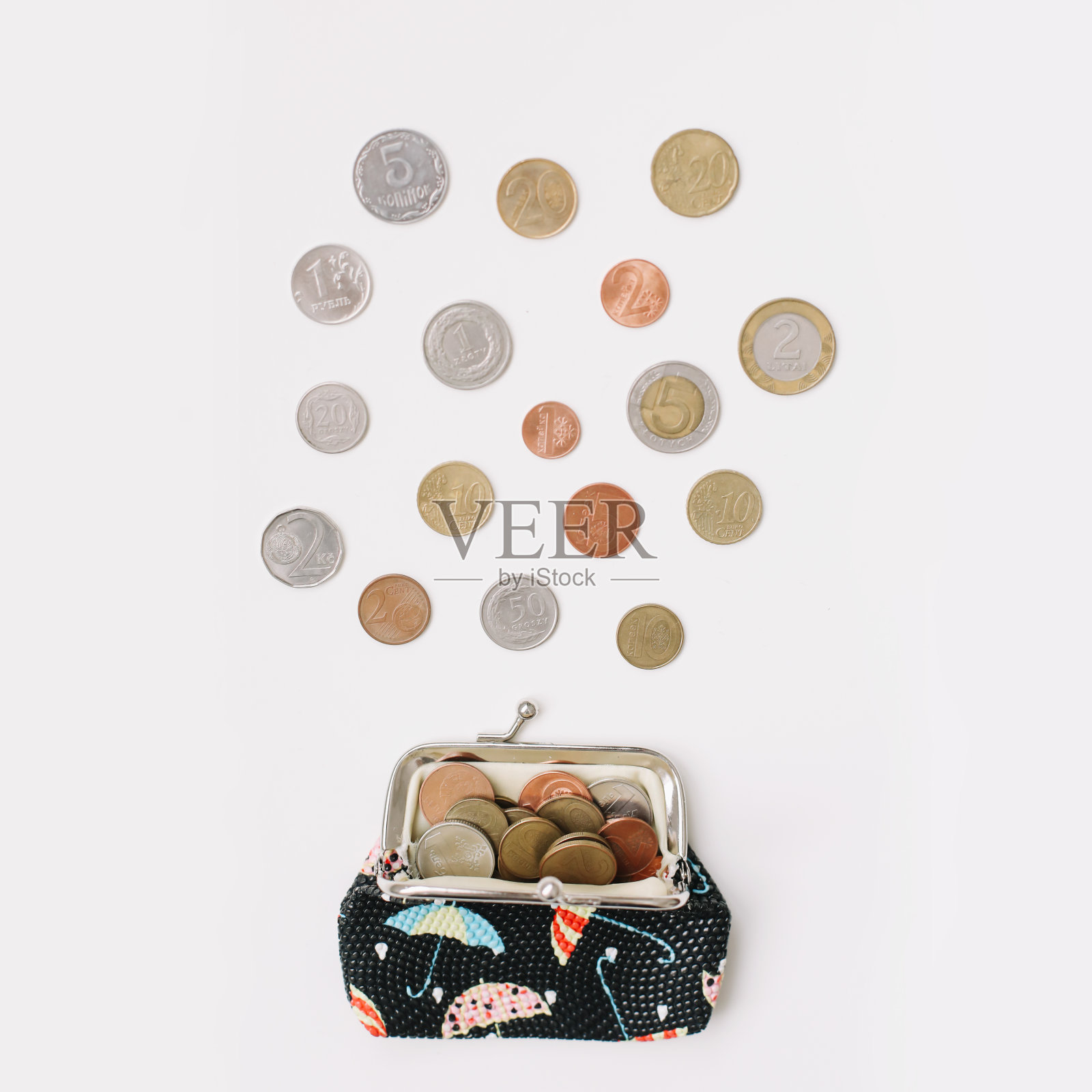 白色背景下，装满不同硬币的打开的钱包俯视图。金融危机、贫困、缺钱概念照片摄影图片