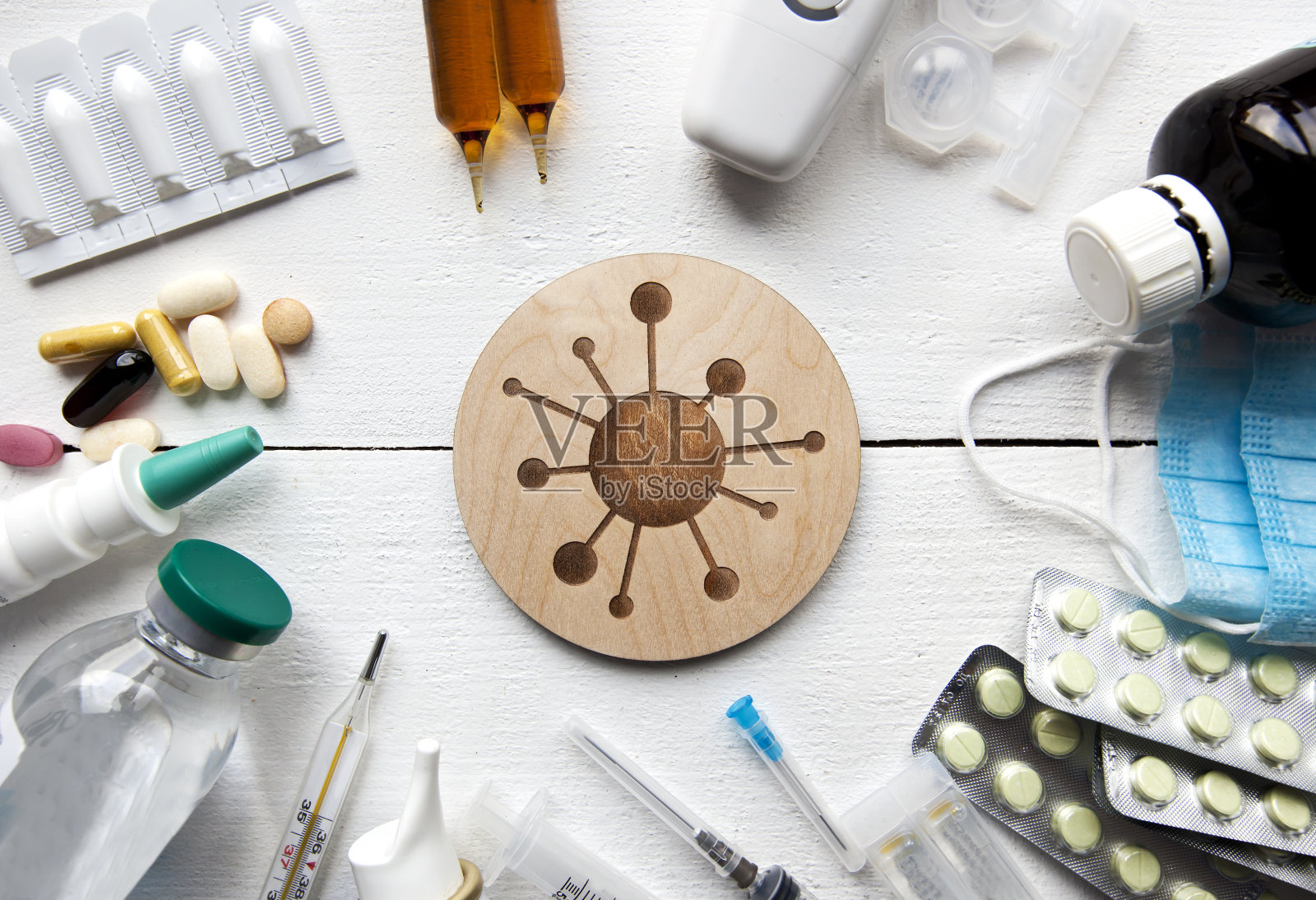 许多不同的药物、药片和其他药物放在白色的木桌上，它们之间象征着病毒照片摄影图片