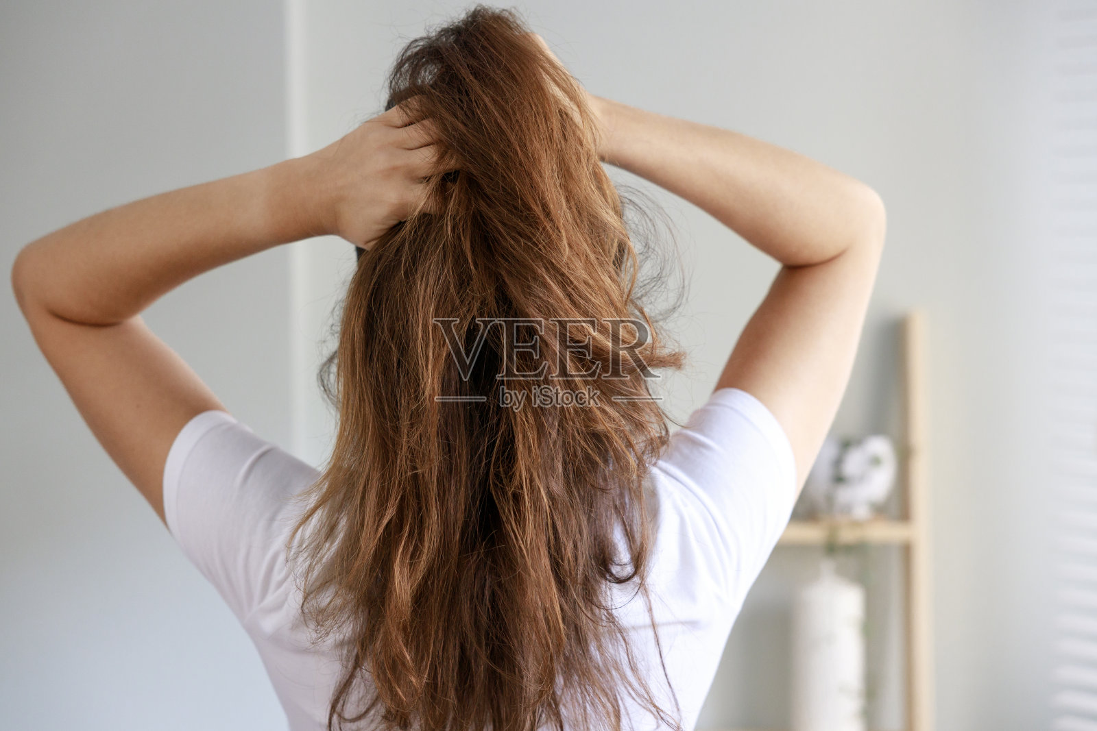 年轻女子在后视镜中摆弄凌乱的头发照片摄影图片