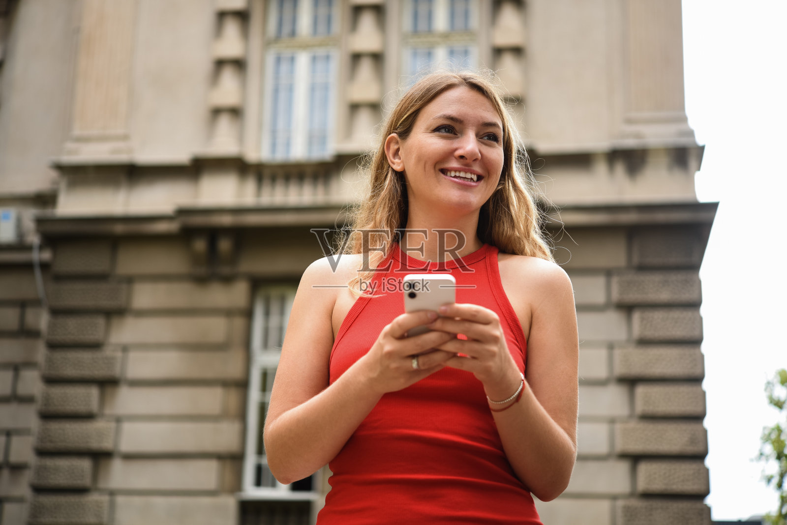 一个美丽的年轻女子在城市中使用智能手机的肖像照片摄影图片
