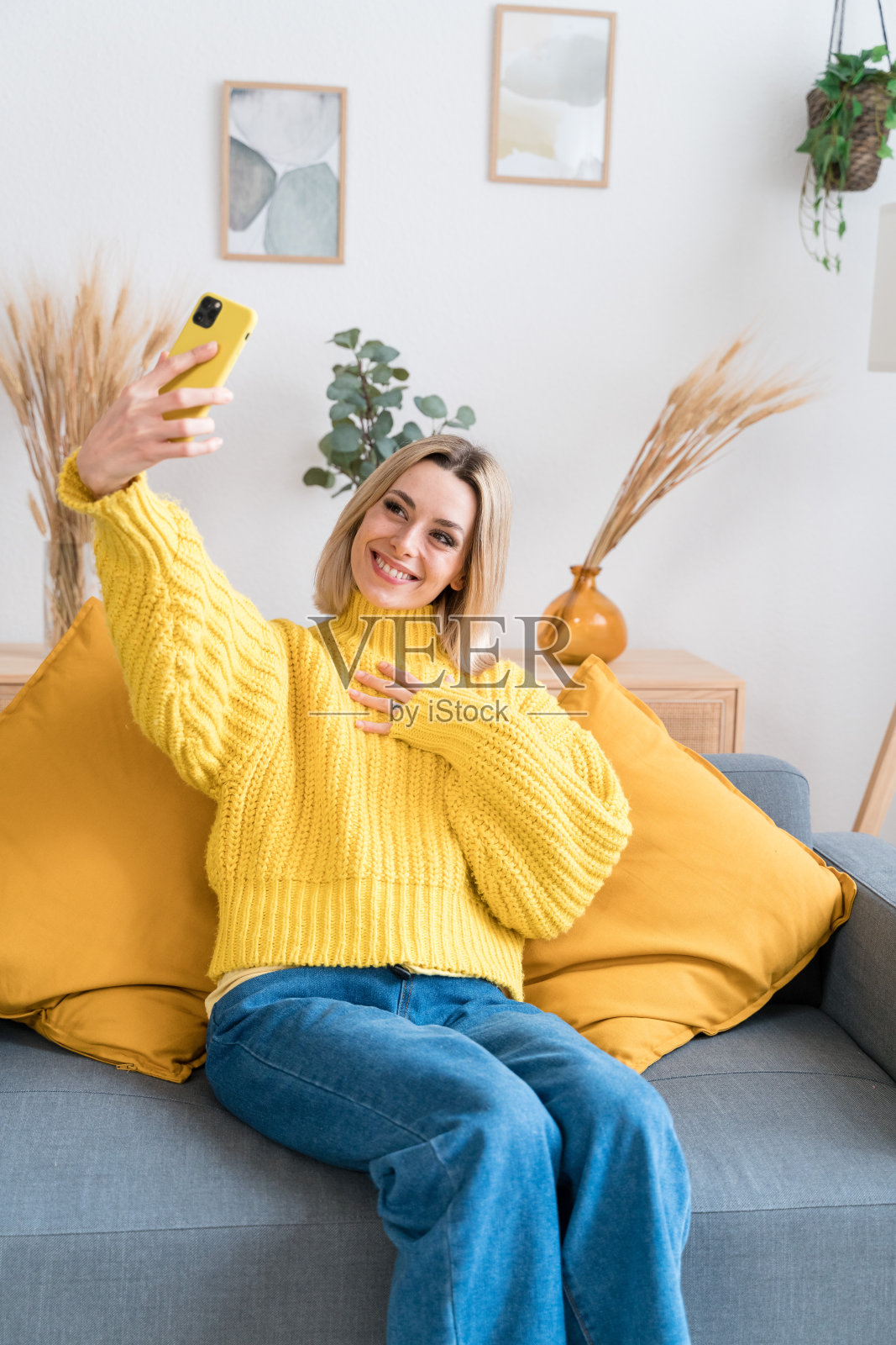 快乐的女人用智能手机自拍照片摄影图片