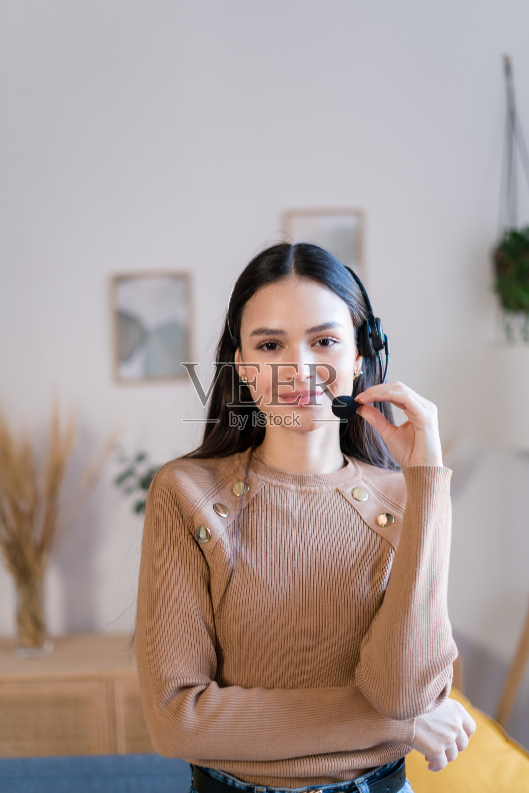 戴着耳机的微笑女人站在办公室照片摄影图片