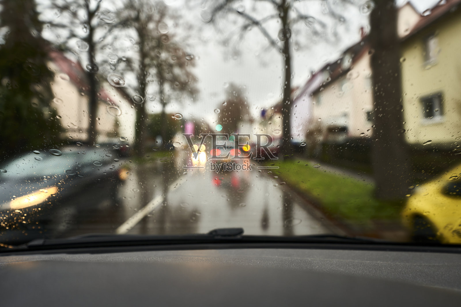 在能见度低、路面潮湿的情况下驾驶汽车。雨点打在挡风玻璃上。照片摄影图片