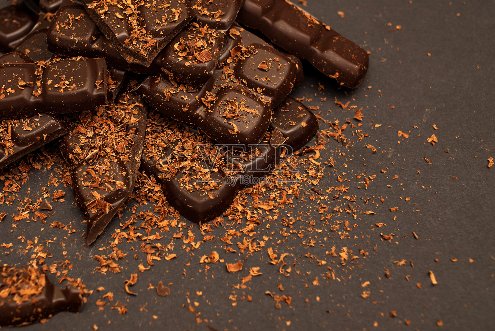 黑色背景上的黑巧克力和牛奶巧克力碎片，特写照片摄影图片