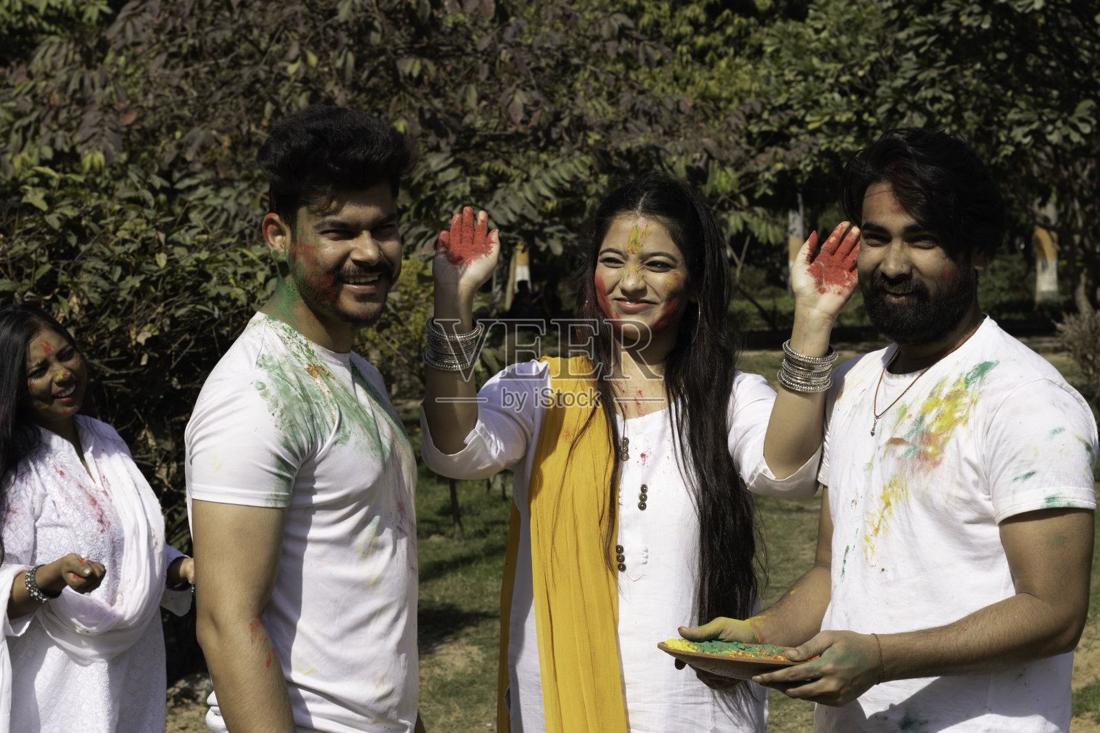 朋友，家庭，男孩，女孩，男人，女人，在公园外庆祝，享受胡里节的颜色和古拉尔啤酒的颜色粉末，一个流行的印度节日在印度庆祝照片摄影图片