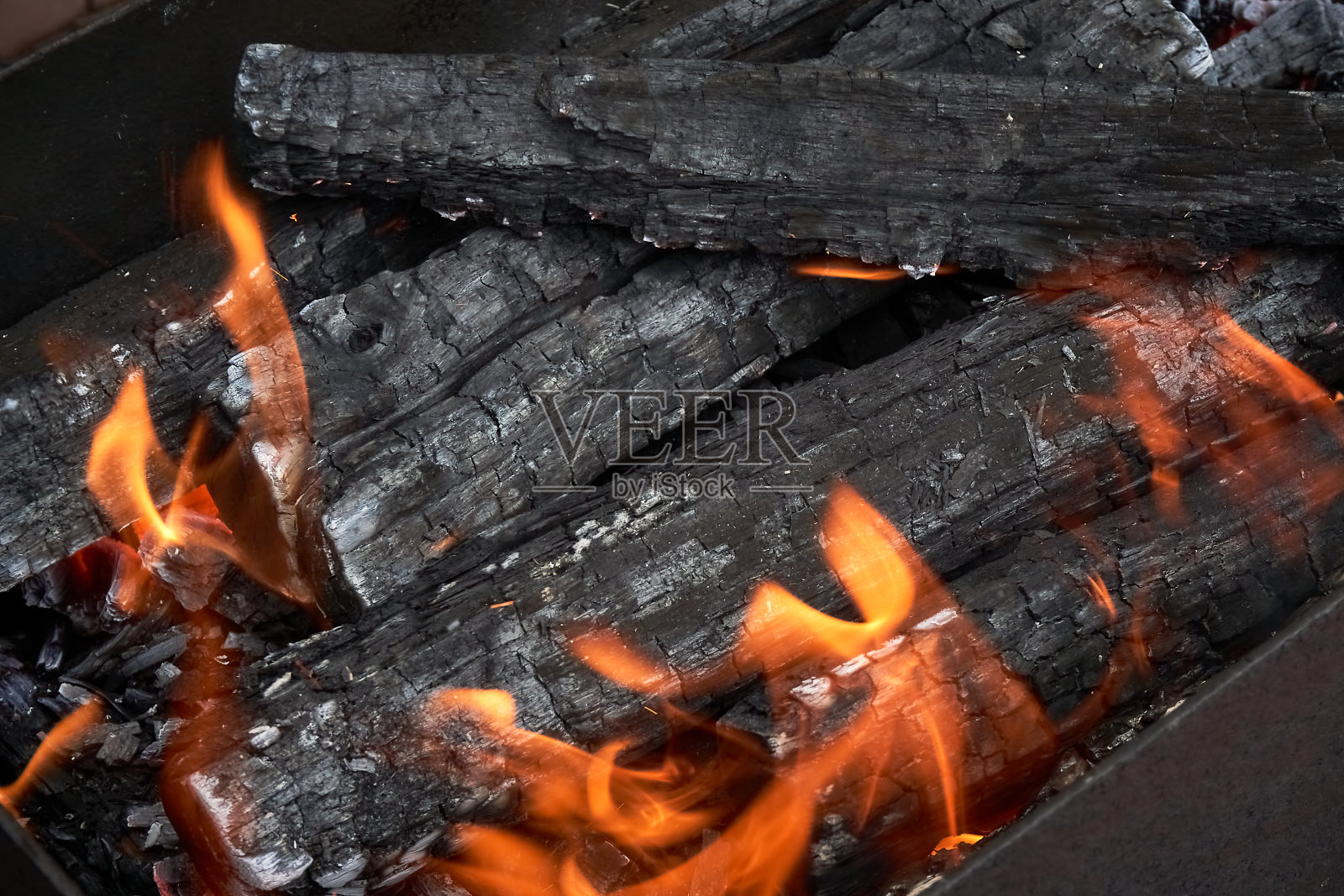 在烤炉中燃烧被火覆盖的木炭，为烧烤做准备照片摄影图片