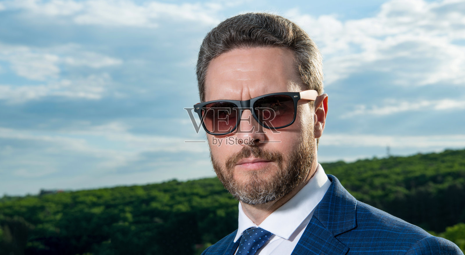 严肃的男人戴着太阳镜的肖像。头发花白，脸上没有刮胡子的男人。专业的人照片摄影图片