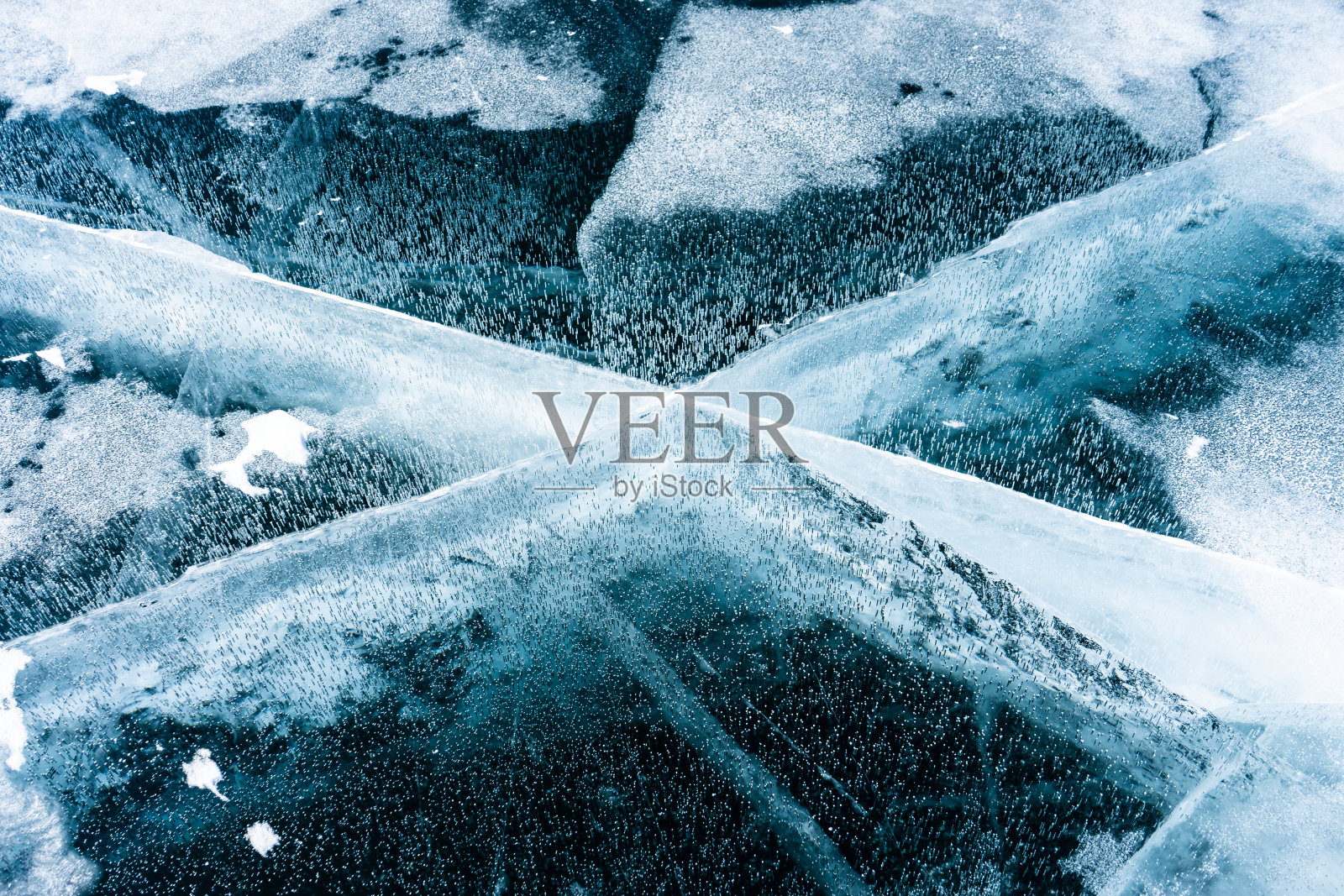 从顶部看，结冰的湖面上有裂缝。鼠标的背景。照片摄影图片