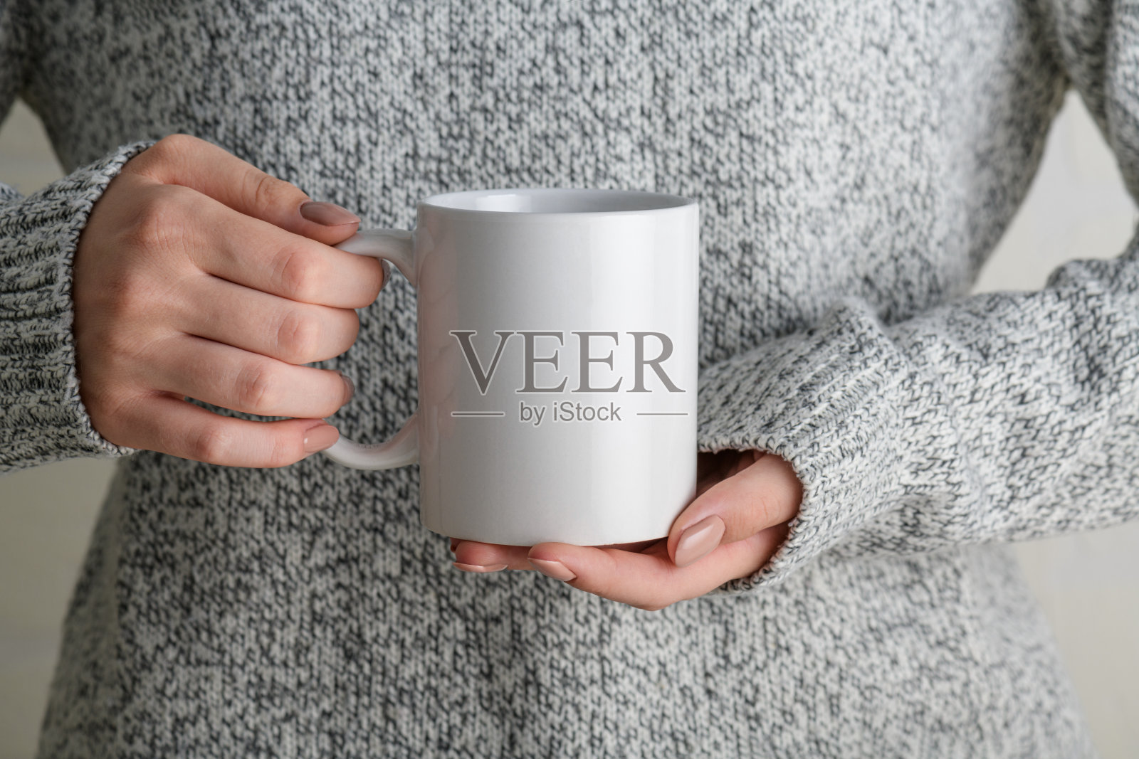 女孩在灰色毛衣拿着白瓷咖啡杯模拟，接近照片摄影图片