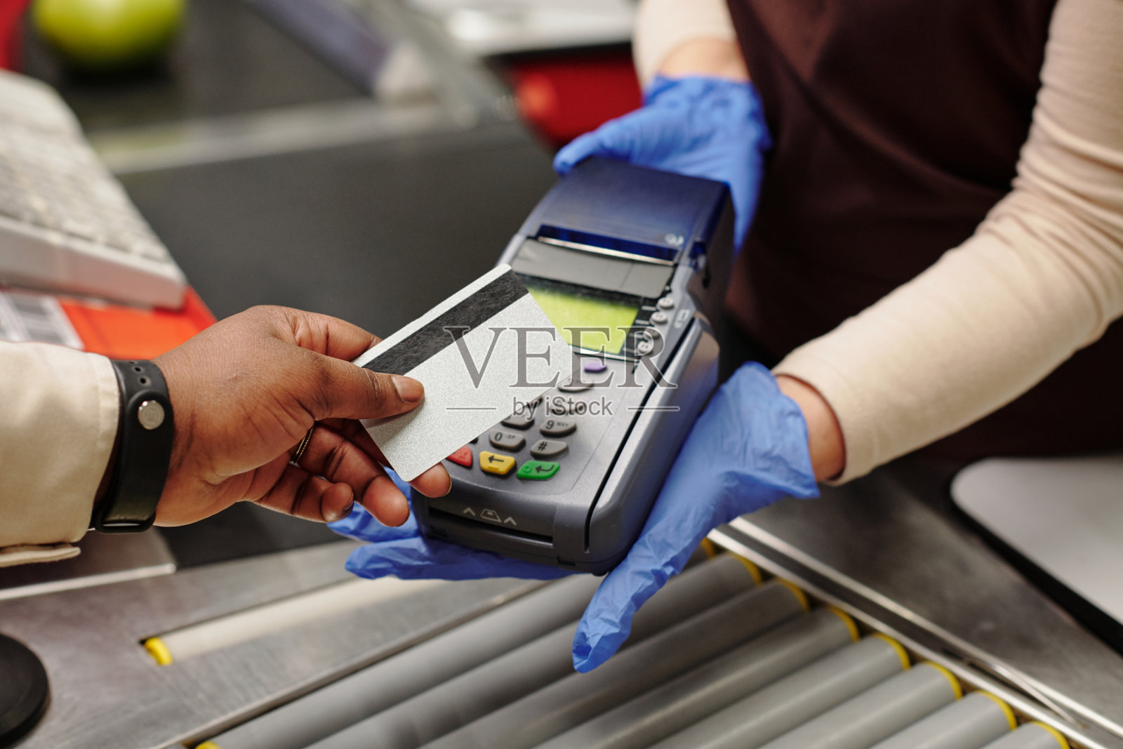 特写女收银员戴手套拿着读卡器在柜台照片摄影图片