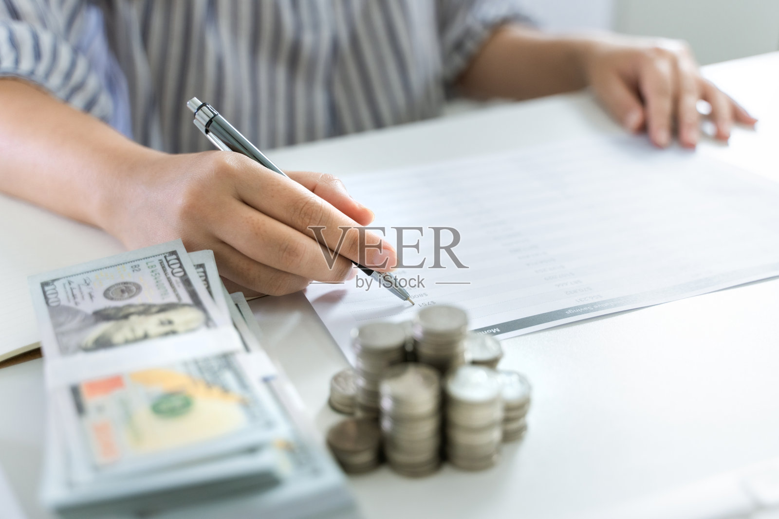 省钱的概念，年轻女性计算个人财务。照片摄影图片