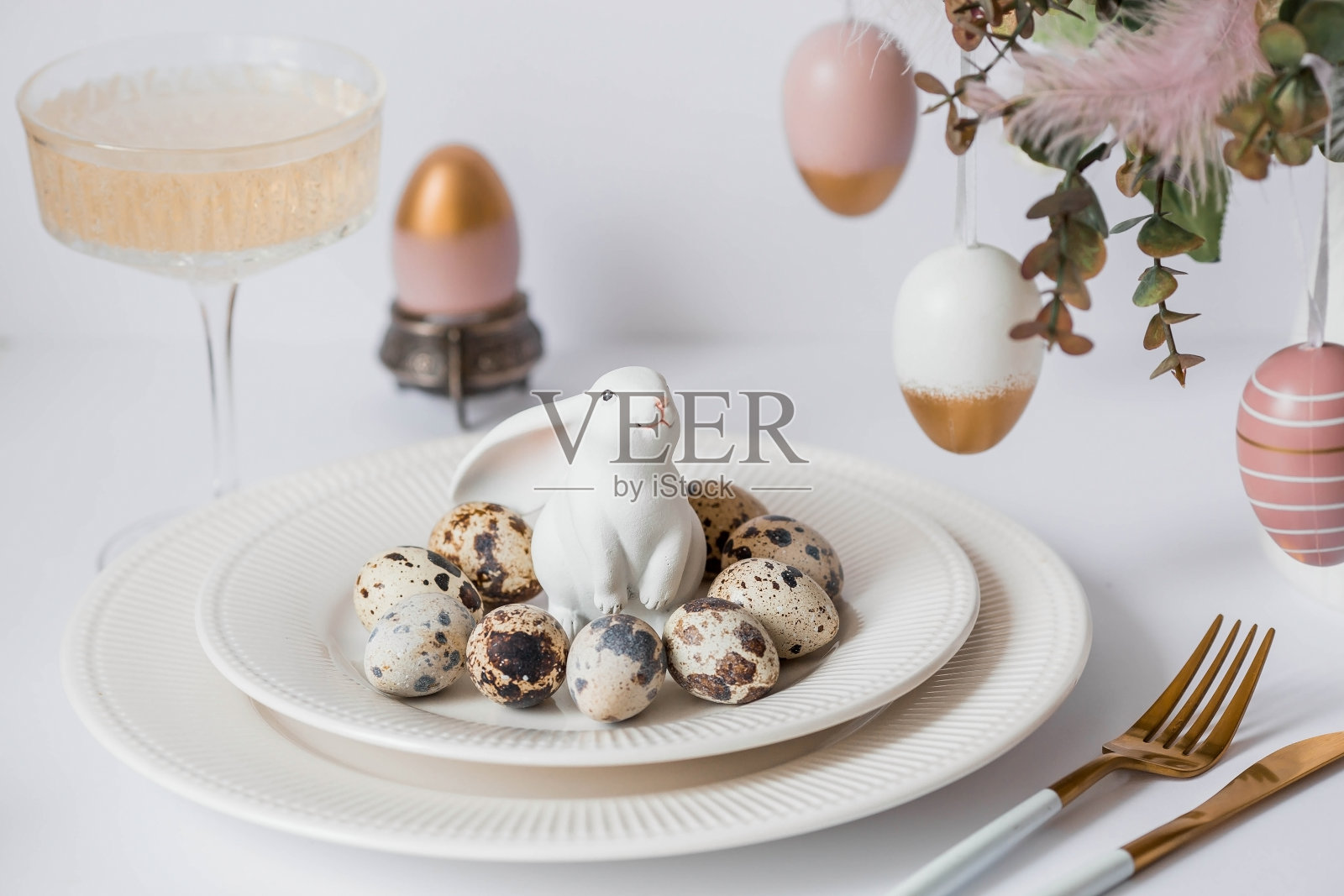 横幅。一个明亮的复活节假期的概念。一束有羽毛、白兔和复活节彩蛋的花，盘子里的白色背景。漂亮的复活节卡片。照片摄影图片