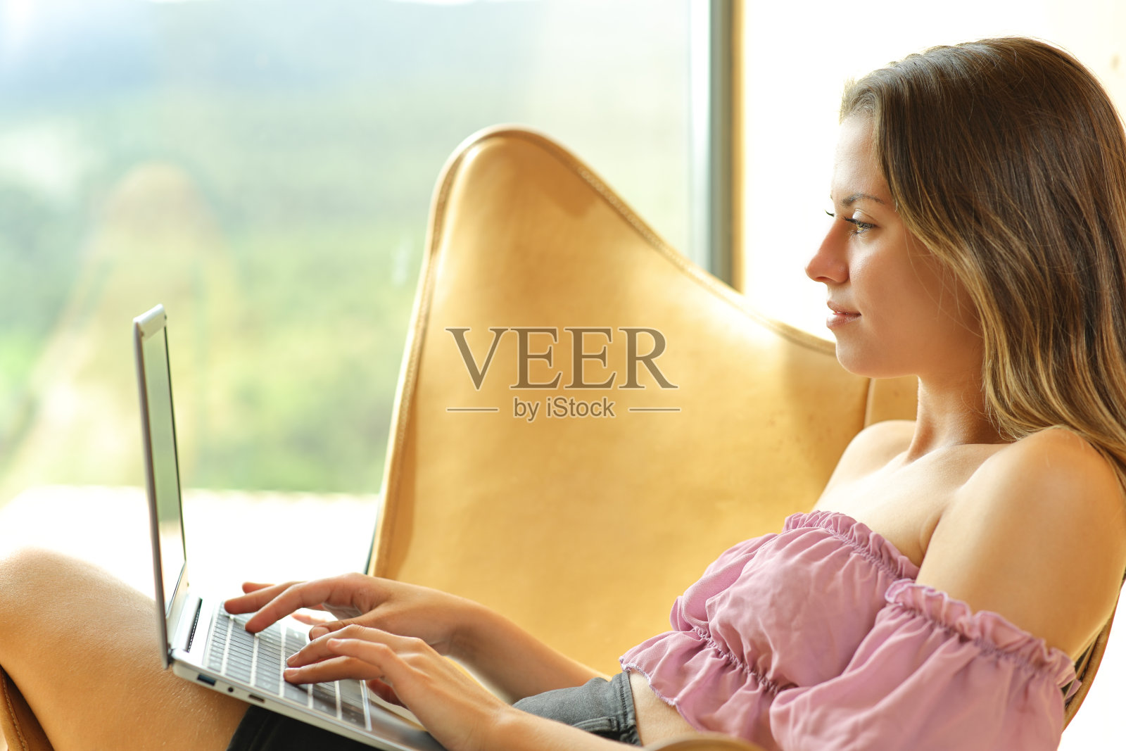 青少年在家里的椅子上使用笔记本电脑照片摄影图片