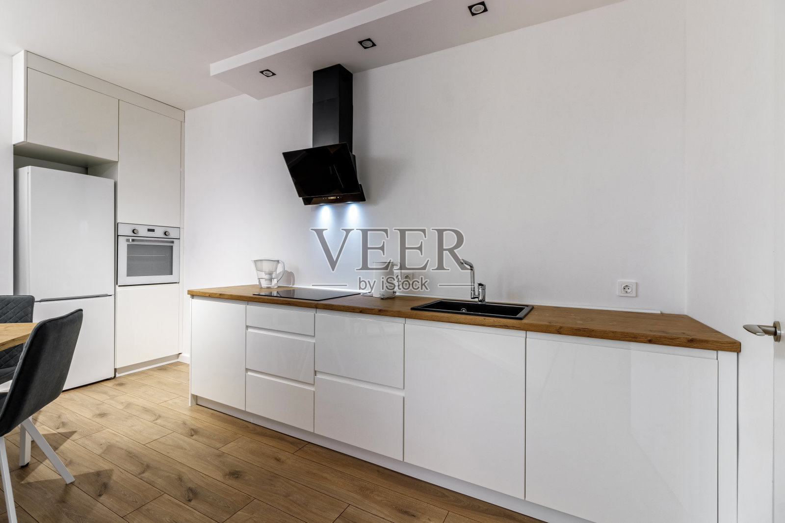 现代化的厨房内部，木制家具和时尚的桌椅。宽敞豪华的公寓空间。照片摄影图片