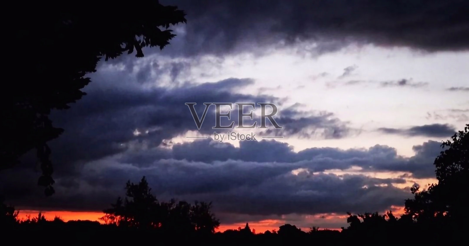 紫罗兰色和红色黑暗的暴风雨黄昏照片摄影图片