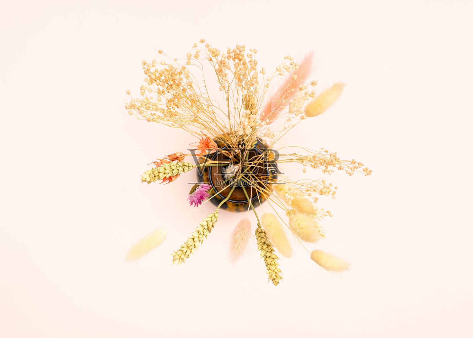 顶部视图的各种干燥植物在花瓶上的粉红色照片摄影图片