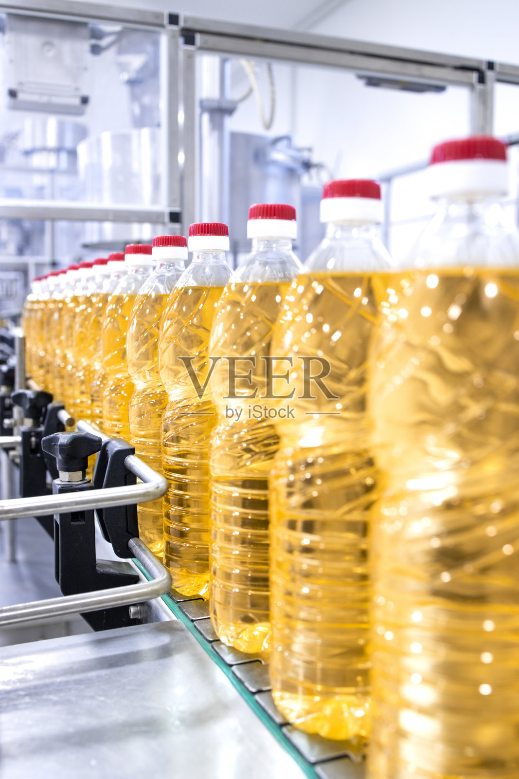 生产瓶装精制烹饪植物油。照片摄影图片