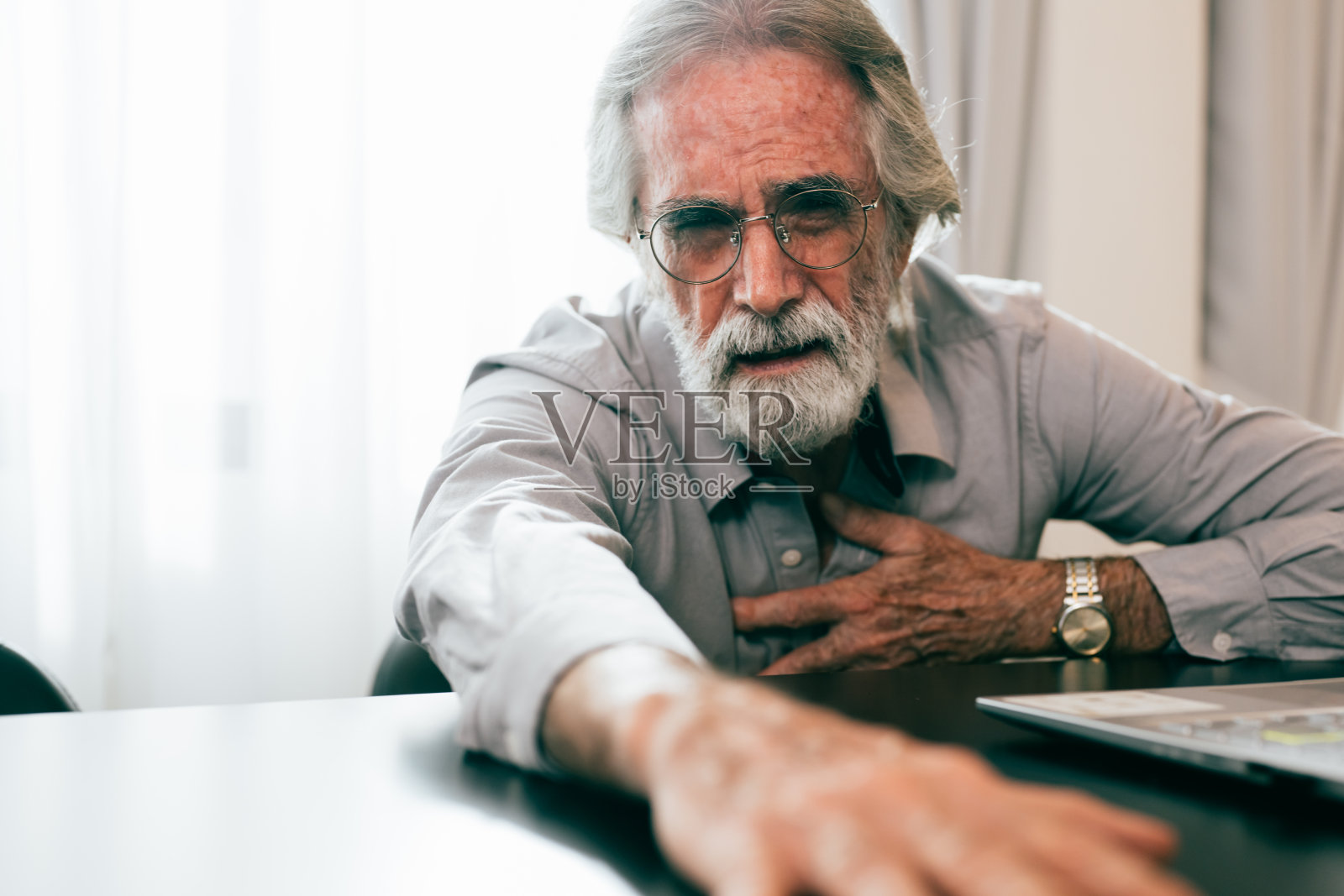 在家捂胸口，患有心脏病的老年男人照片摄影图片