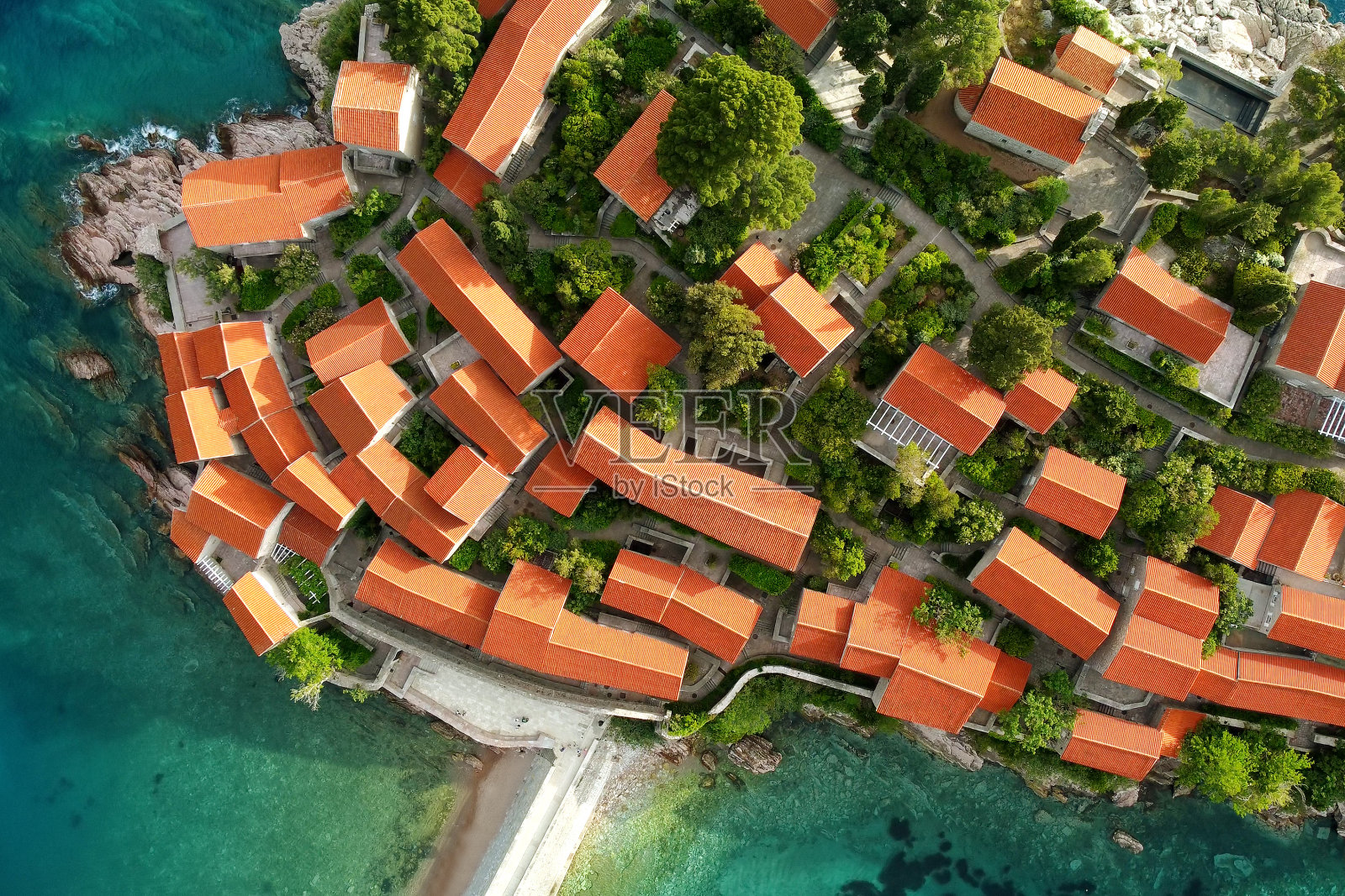 Sveti Stefan岛与历史小镇的惊人日落空中无人机视图。从上到下的风景如画的小岛在亚得里亚海位于黑山。照片摄影图片