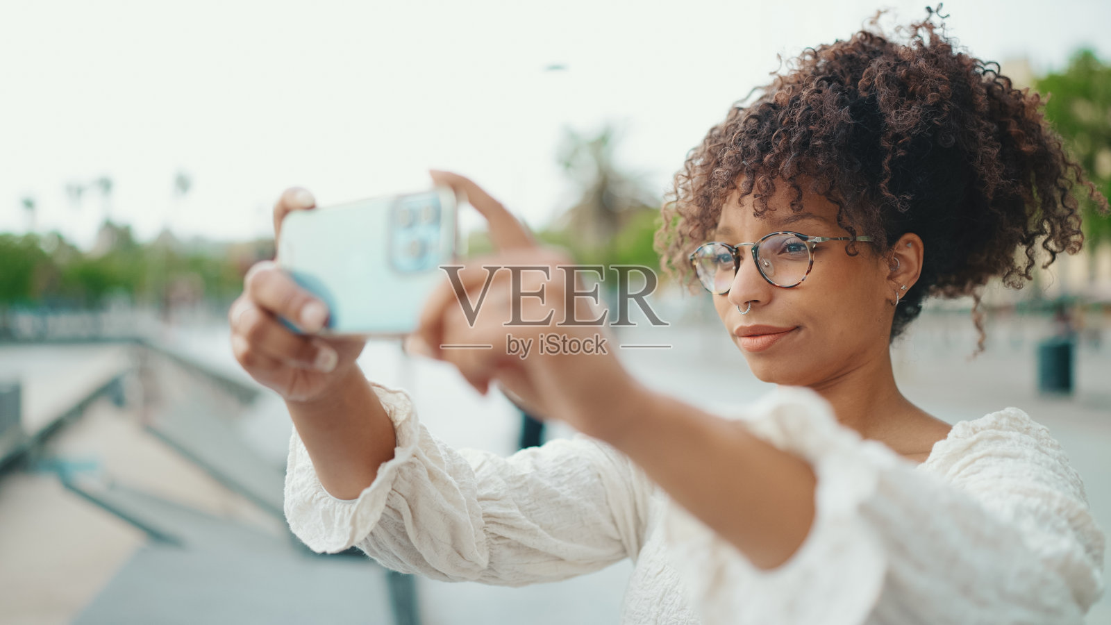 戴眼镜的年轻女子在海港用手机拍摄船只特写照片摄影图片