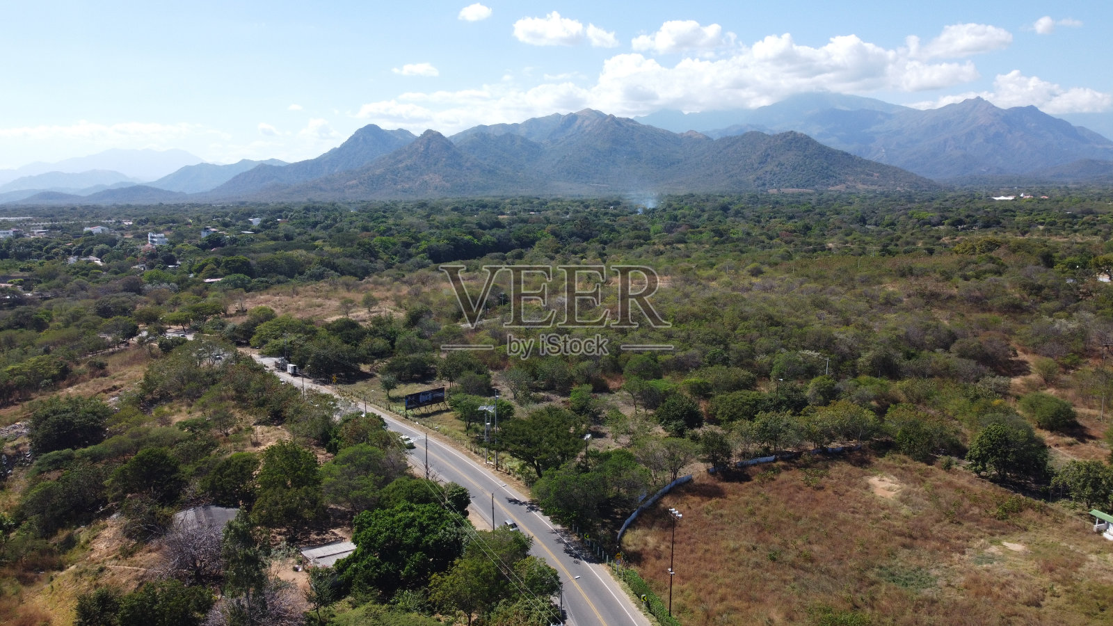 鸟瞰山谷大道树木建筑山峦蓝天照片摄影图片