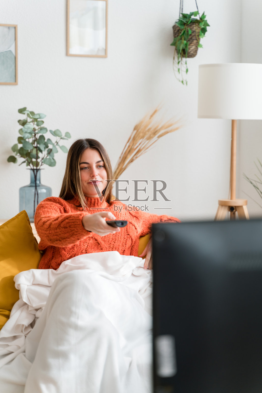 年轻女子在客厅看电视照片摄影图片