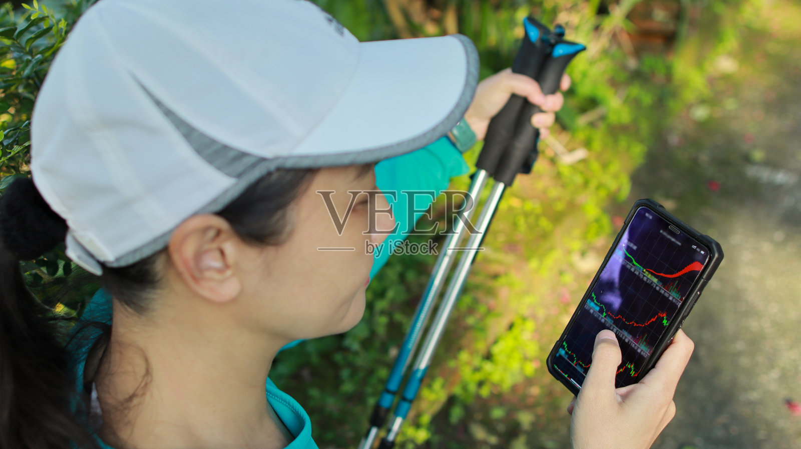 一边用登山杆徒步，一边关注股市新闻照片摄影图片