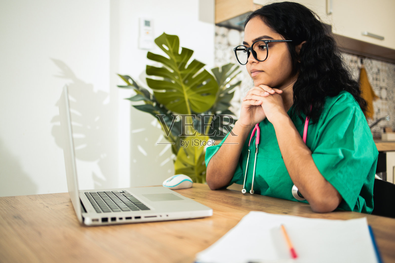 一个美丽的年轻医生听她的在线病人的肖像照片摄影图片