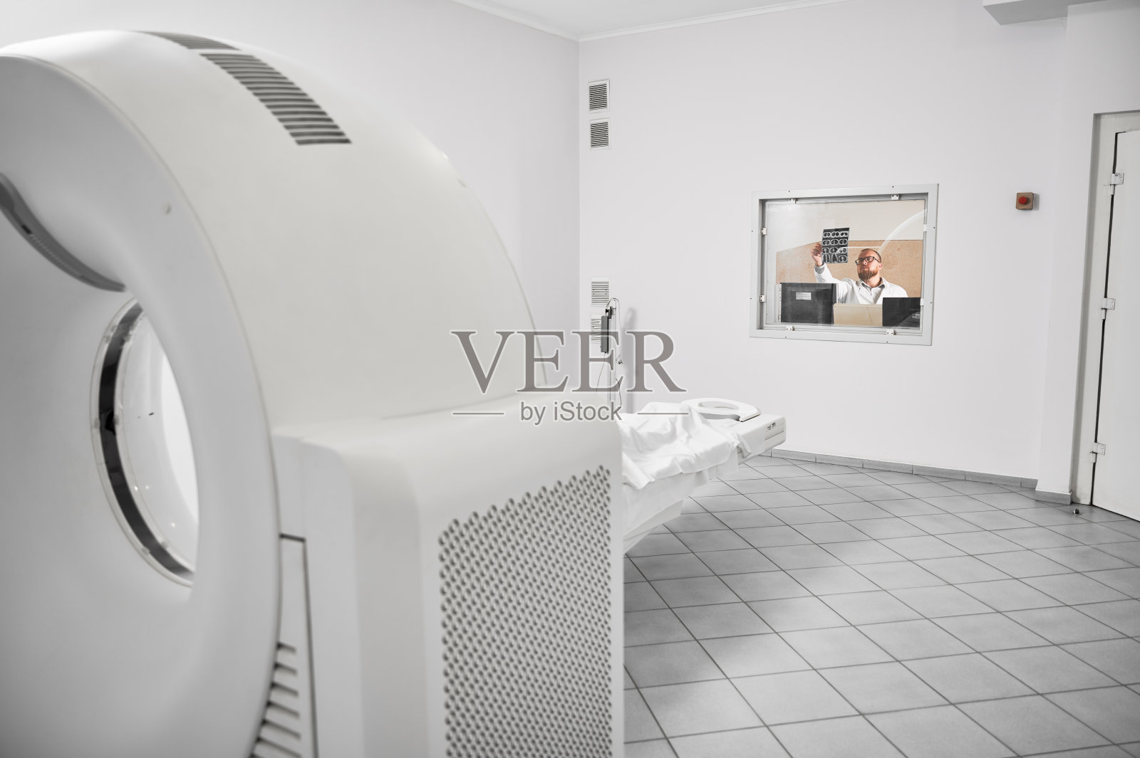 医生坐在电脑前，看核磁共振结果。照片摄影图片